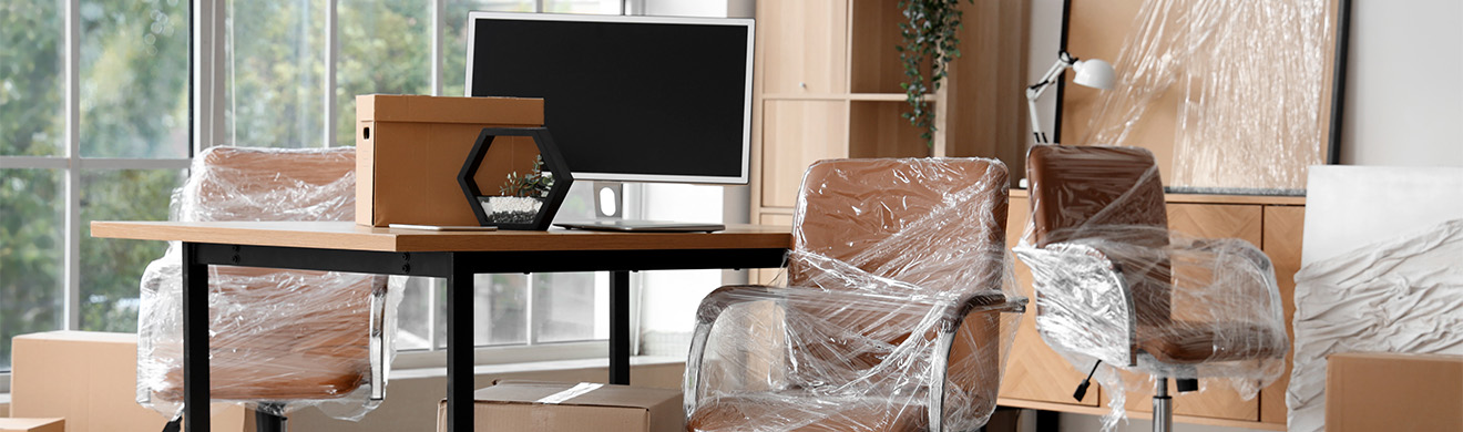 Modernes Büro mit in Stretchfolie verpackten Stühlen und Kartons – typische Szene bei einer Firmenentrümpelung in Kiel.