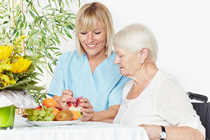 Altenpflegerin hilft Seniorin beim Essen