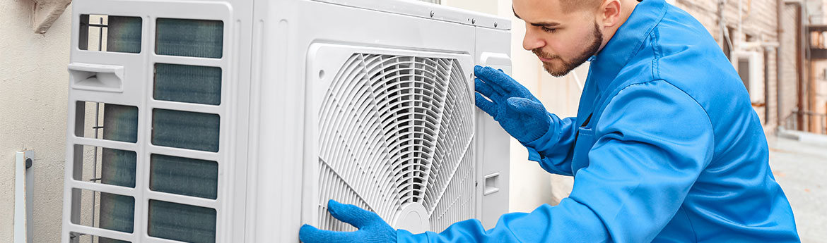 Männlicher Techniker, installiert ein Außengerät der Klimaanlage