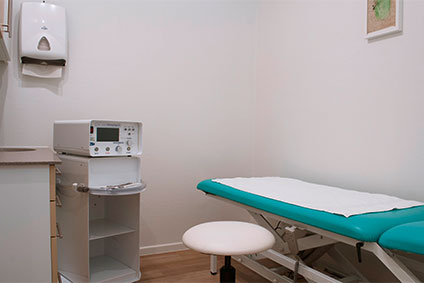 Behandlungsraum mit Behandlungsbank, Atmosphärenlicht und minimaler medizinischer Ausstattung für Osteopathiebehandlung in Kiel