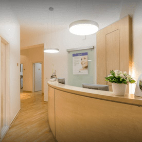 Empfangsbereich der Hautarztpraxis Behrendt in Eutin mit Tresen, Sitzbereich und freundlichem Ambiente.