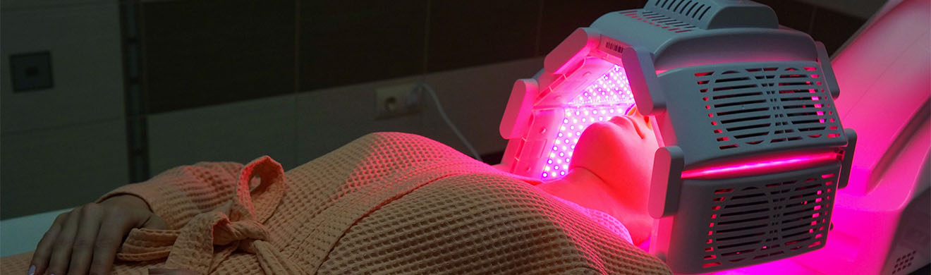 Patient unter rotem Licht zur Bestrahlung bei photodynamischer Therapie in Eutin.