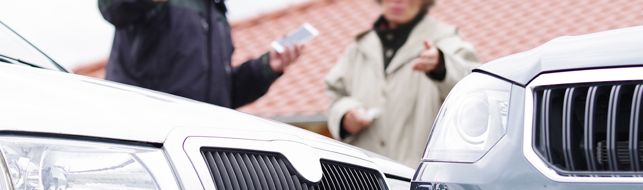 Zwei Autofahrer diskutieren nach einem Autounfall, während ein Unfallanwalt in Kiel rechtliche Unterstützung bietet.